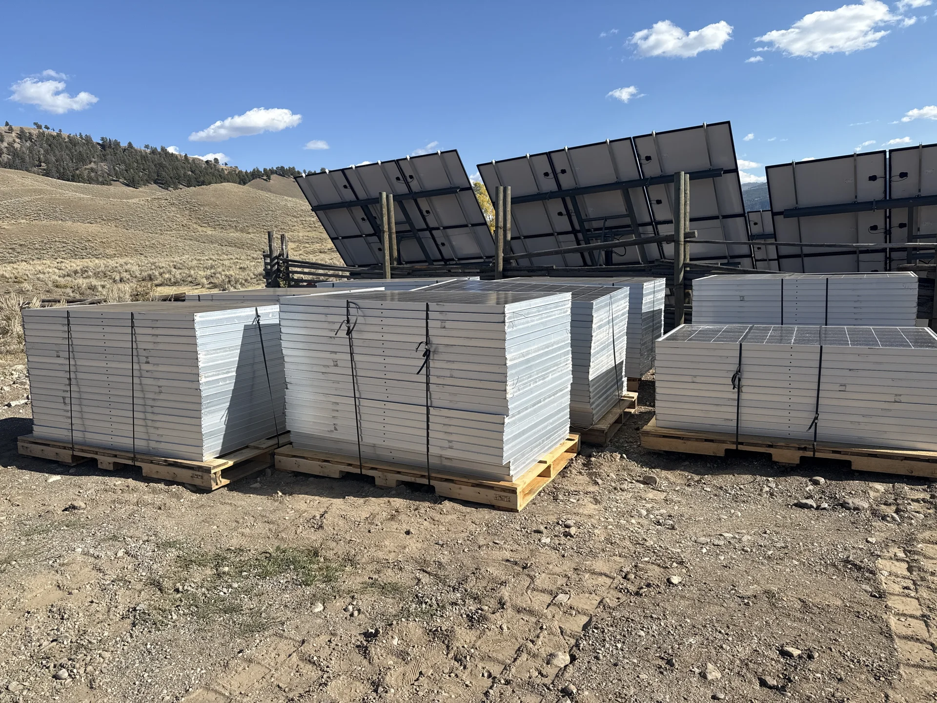 Stacks of donated solar panels secured on pallets and ready for collection.
